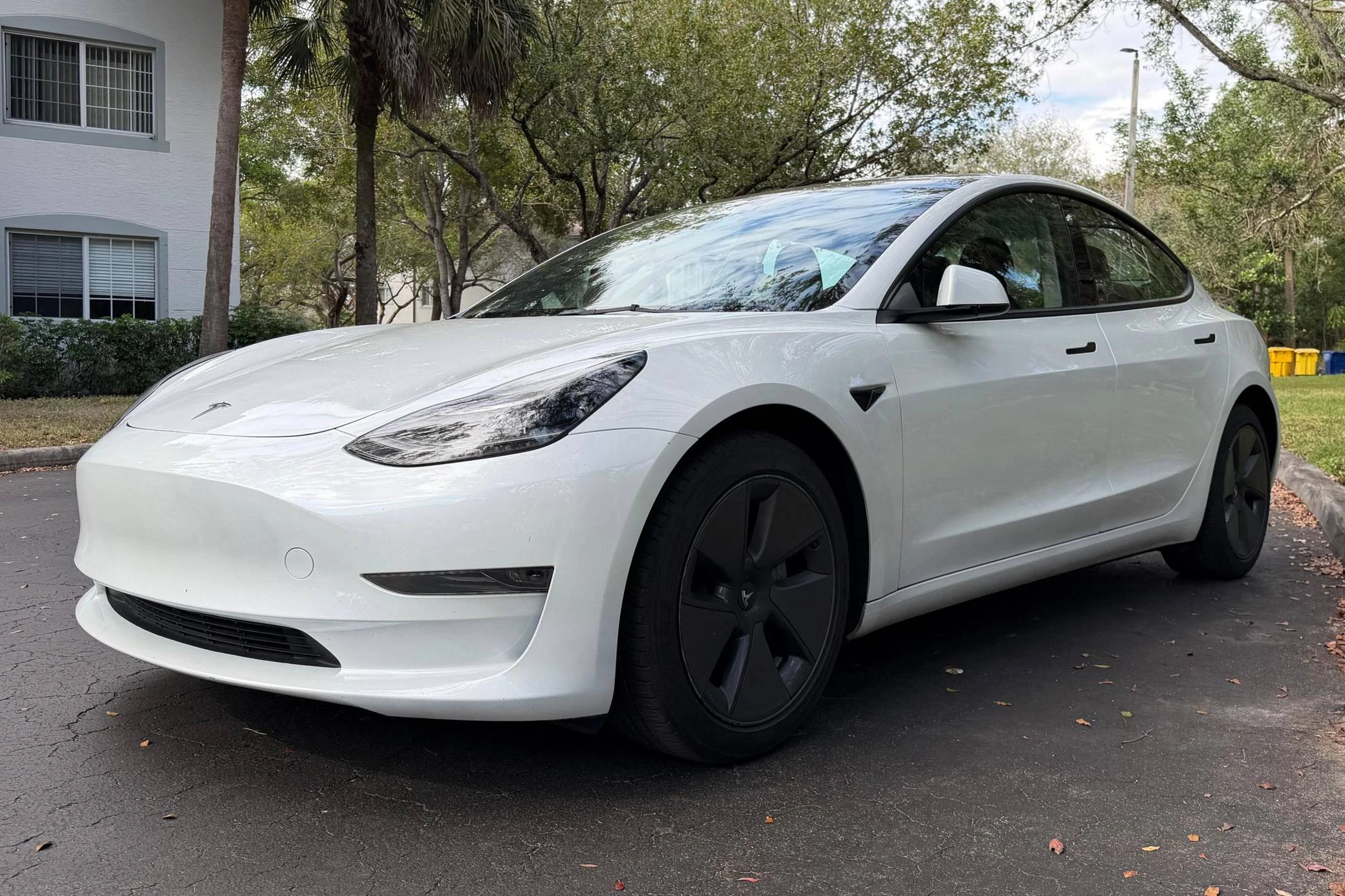 Original photo of a light electric sedan before an AI wheel change