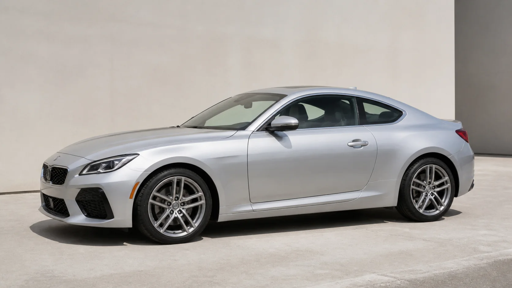 Silver coupe photographed from a clear three-quarter side angle with both wheels visible